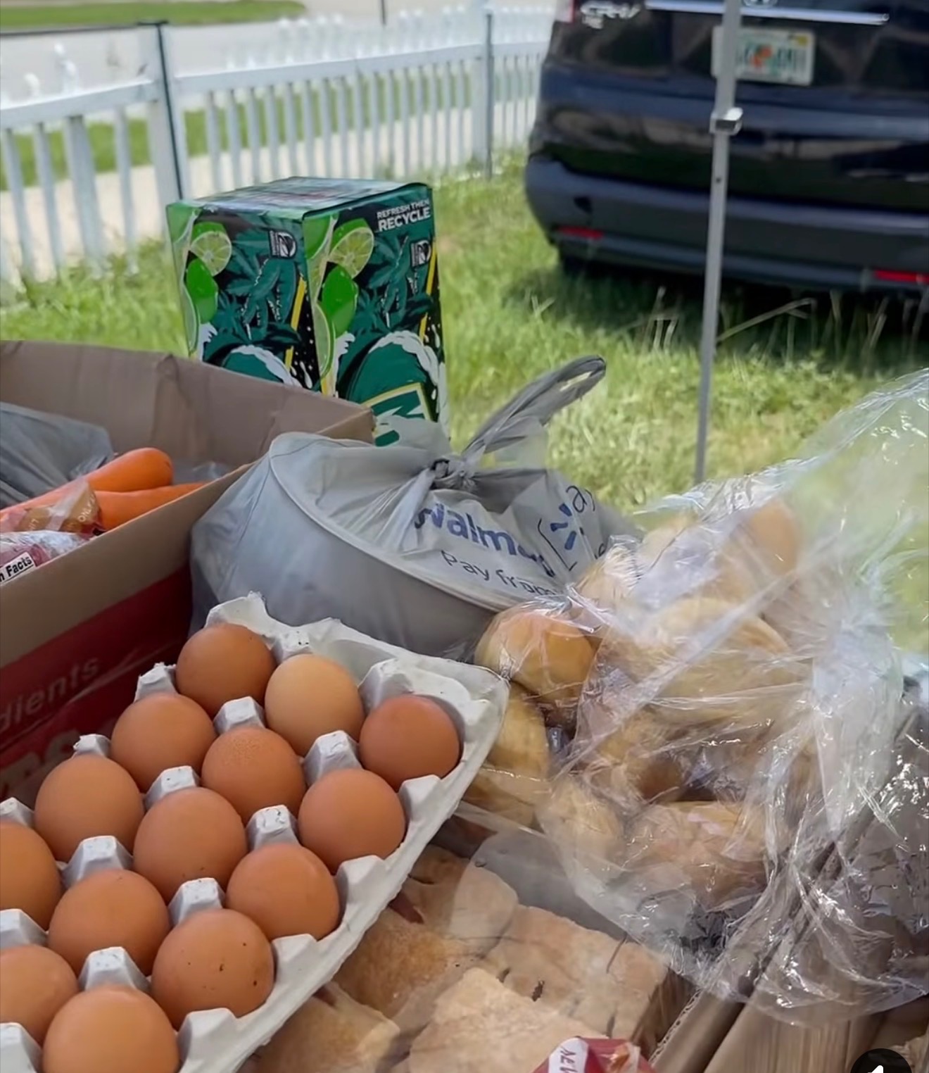Groceries including eggs, bread rolls and carrots laid out for distribution